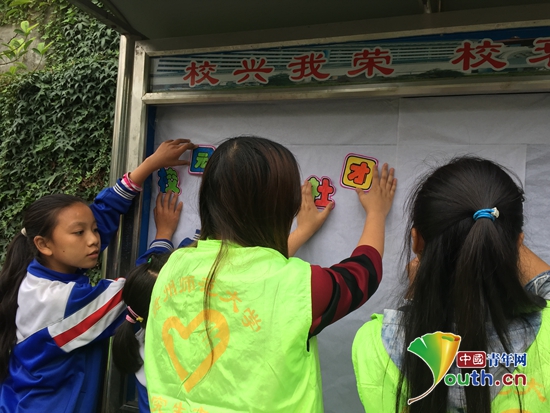 贵州师范大学支教团成员和学生们一起制作公示栏。唐婉贞供图 贵州师范大学支教团成员和学生们一起制作公示栏。唐婉贞供图